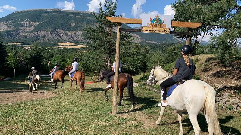 Enfants sur chevaux devant montagne centre vacances d'Istremont dans les hautes alpes 